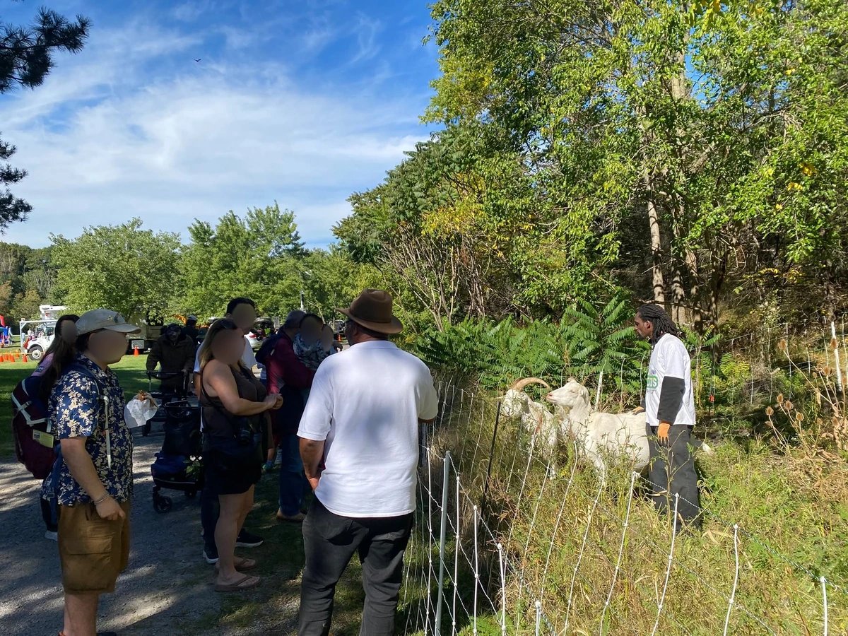 Visitors learn about prescribed grazing while the goats browse nearby.