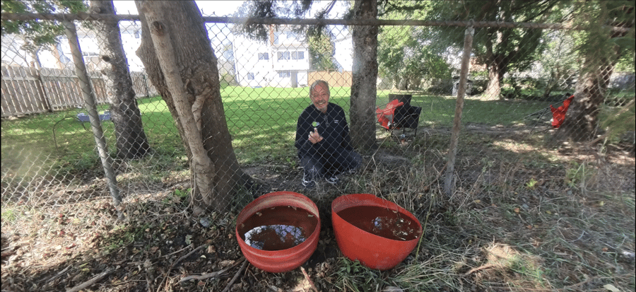 Ken, a nearby resident, beside the goats' water containers at the Highway 7/8 site